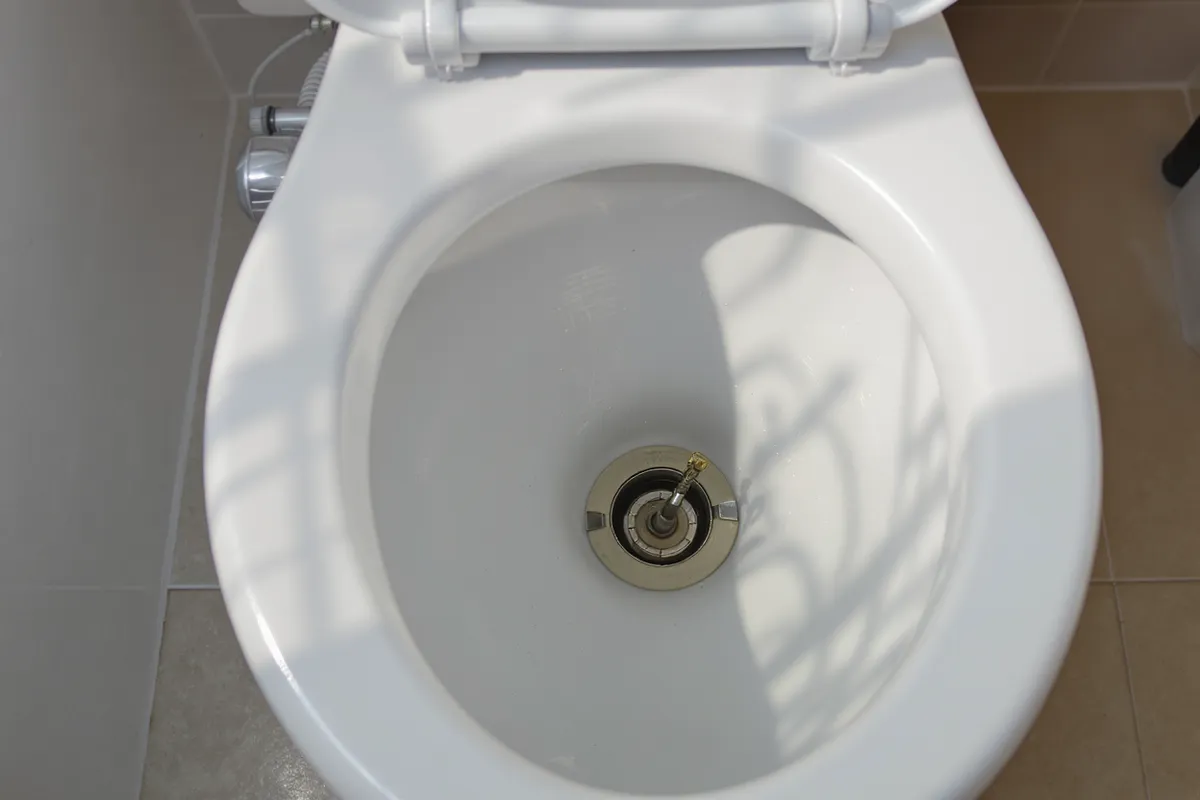 Toalett där vattnet rinner hela tiden i toalettstolen